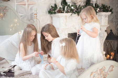 Little girls sisters or friends are doing needlework in the bedroom. Retro style.の写真素材