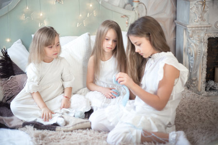 Little girls sisters or friends are doing needlework in the bedroom. Retro style.の写真素材