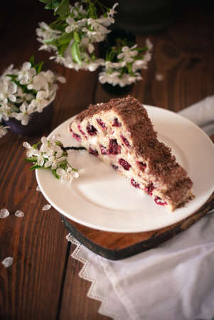 Homemade cake with cherries and cream on a wooden table. Dessert close-up.の写真素材