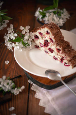 Homemade cake with cherries and cream on a wooden table. Dessert close-up.の写真素材