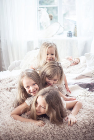 Little girls sisters in the morning in bed. Vintage style, Christmas holidays. Studio photoの写真素材