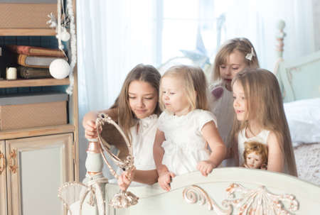 Little girls play in the bedroom in the morning before Christmas. The concept of family, sisterhood, friendship. Winter holidays, Christmas, New Year.の写真素材
