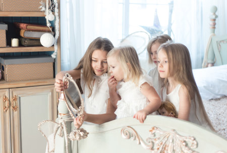 Little girls play in the bedroom in the morning before Christmas. The concept of family, sisterhood, friendship. Winter holidays, Christmas, New Year.の写真素材