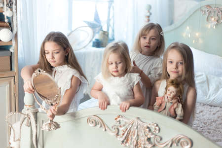 Little girls play in the bedroom in the morning before Christmas. The concept of family, sisterhood, friendship. Winter holidays, Christmas, New Year.の写真素材