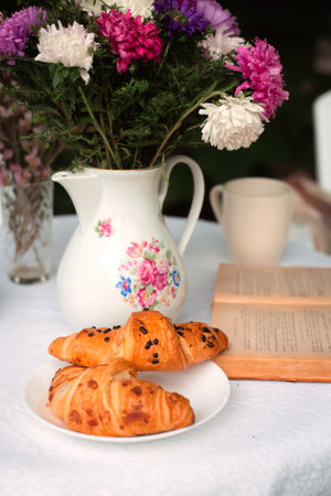 Croissants on a plate in a summer garden or on a terrace in a cafe close-up.の写真素材