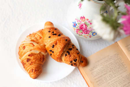 Croissants on a plate in a summer garden or on a terrace in a cafe.の写真素材