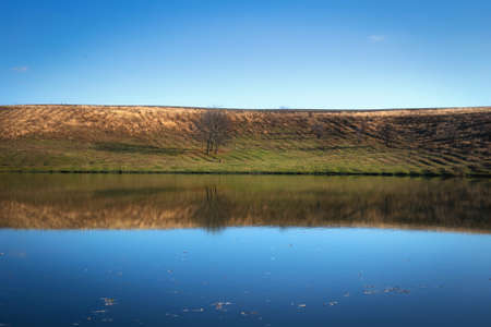 The calm surface of the lake on a quiet autumn day. Peaceful landscape in autumn. High quality photoの写真素材