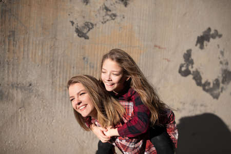 Young mother and daughter are having fun on a walk on a sunny warm day.の写真素材