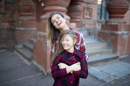 Young mother and daughter are having fun on a walk on a sunny warm day.の写真素材