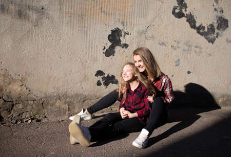 Young mother and daughter are having fun on a walk on a sunny warm day.の写真素材