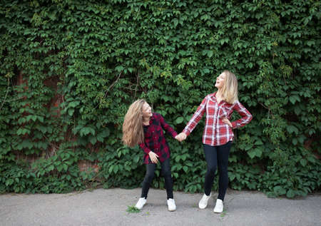 Young mother and daughter are having fun on a walk on a sunny warm day.の写真素材