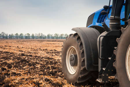 Modern tractor in the field during planting. The concept of agricultural industry.の写真素材