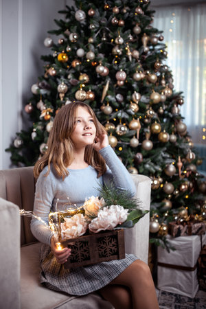 Cute teenage girl in a room with a decorated Christmas tree. The winter holidays. high quality photoの写真素材