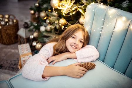 Cute teenage girl in a room with a decorated Christmas tree. The winter holidays. high quality photoの写真素材