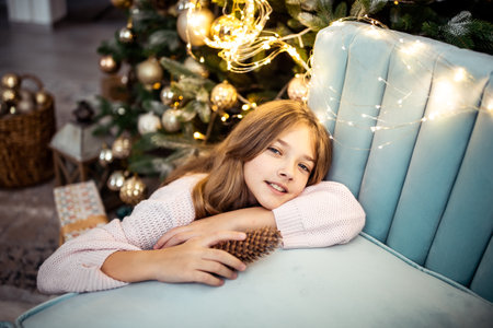 Cute teenage girl in a room with a decorated Christmas tree. The winter holidays. high quality photoの写真素材