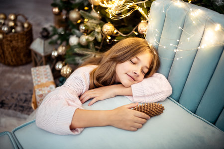 Cute teenage girl in a room with a decorated Christmas tree. The winter holidays. high quality photoの写真素材