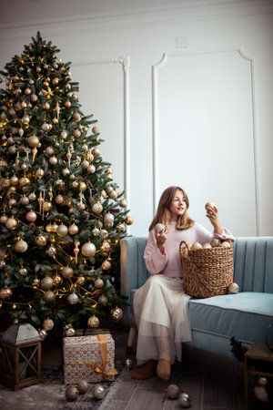 Cute teenage girl in a room with a decorated Christmas tree. The winter holidays. high quality photoの写真素材