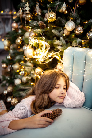 Cute teenage girl in a room with a decorated Christmas tree. The winter holidays. high quality photoの写真素材