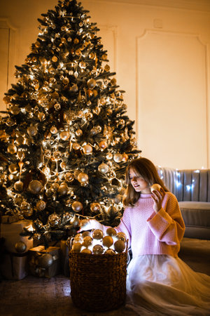 Cute teenage girl in a room with a decorated Christmas tree. The winter holidays.の写真素材