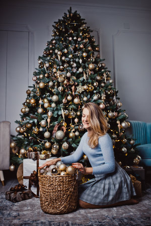 Young woman near the Christmas tree. Winter holidays.の写真素材
