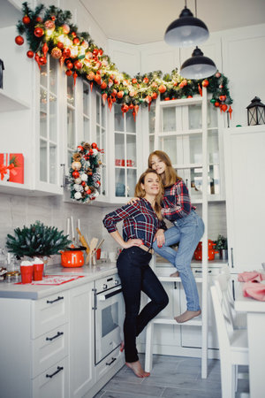 Mom and daughter in the kitchen. Winter holidays at home.の写真素材