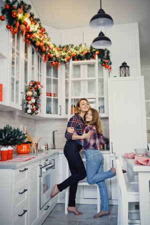 Mom and daughter in the kitchen. Winter holidays at home.の写真素材