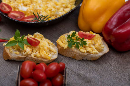 Scrambled eggs in an iron pan on the rustic wooden tableの写真素材