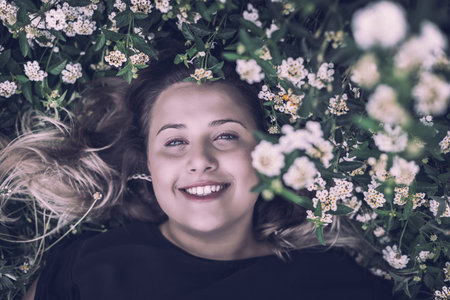 Portrait of a young beautiful brunette woman in park