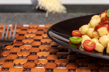 Close up on traditional italian potato gnocchi in tomato sauce with fresh basil and Cherry tomato