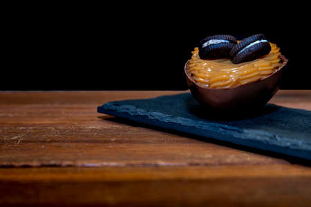 Chocolate easter eggs on top of black stone with wooden backgroundの写真素材