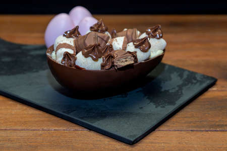 Chocolate easter egg on top of black stoneの写真素材