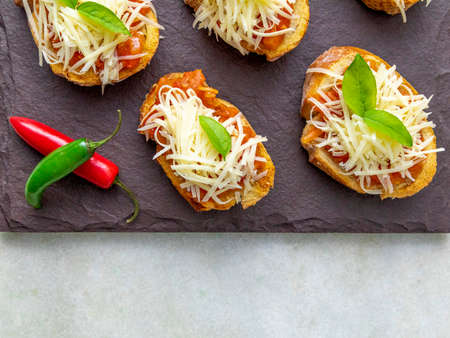 bruschetta toasts with cherry tomatoes, mozzarella and basil. Top view with space for your textの写真素材