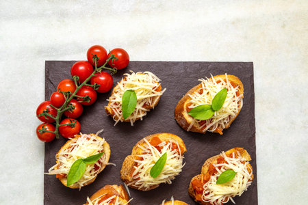 bruschetta toasts with cherry tomatoes, mozzarella and basil. Top view with space for your text