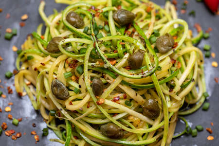 Zucchini spaghetti with dehydrated pepperoni pepper and capers.の写真素材