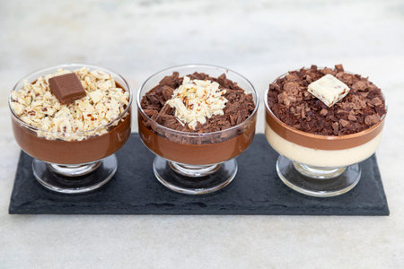 Cup of dessert with milk chocolate mousse and white chocolate shavings and ganache mousse.