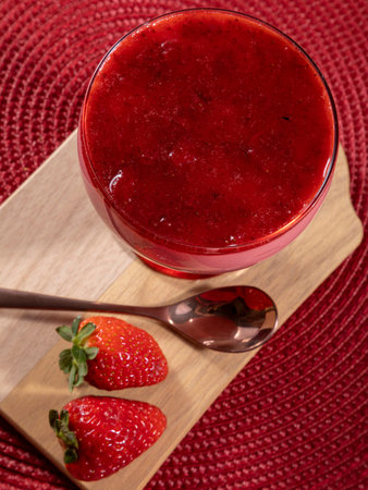Tasty strawberry mousse in glass with gelatin on top.