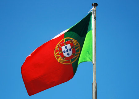 Portuguese flag on a blue skyの写真素材