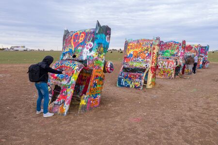 Male making graffiti on rusty vehicleのeditorial素材