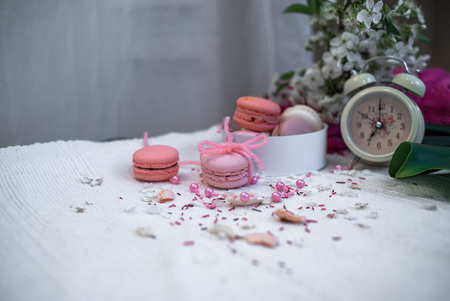 Tender pastel pink and orange macaroons on a white blanket and backgroundの写真素材