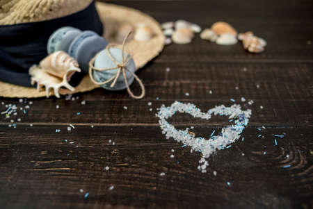 Straw hat with blue macaroons and sea salt with shells on the wood backgroundの写真素材