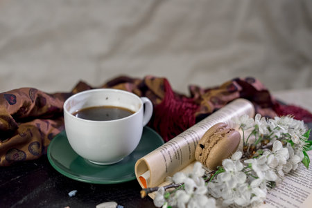A cup of coffee on a white tray with branch of blossomed cherry and monstera leafの写真素材