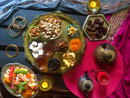 Black Turkish tea in lale with oriental sweets and dried fruits by candlelight