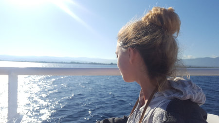 Young woman looking at the sea from a cruise ship. Portrait of a girl on a cruise ship.の写真素材