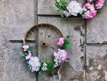 Flowers in bicycles wheel on the wall at the street of Przemysl at springの写真素材
