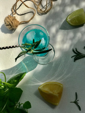 Blue cold drink in a glass with ice cubes on white desk with blue background.の写真素材