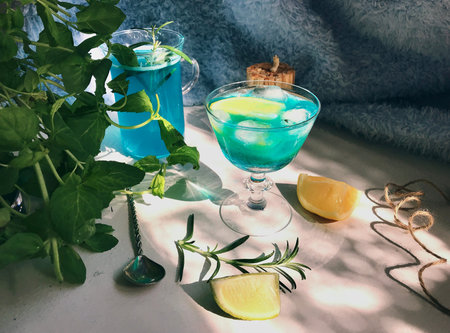 Blue cold drink in a glass with ice cubes