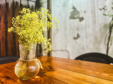 Artificial dry colored flowers in a large green glass vase as a part of interior designの写真素材