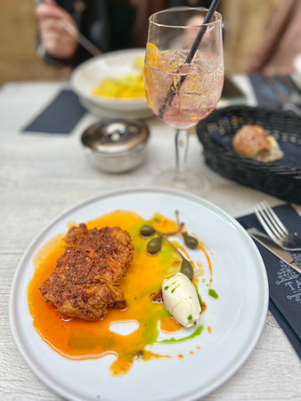 Buttermilk fried chicken and capers on white plate with honey butter at Valetta restaurant, Malta