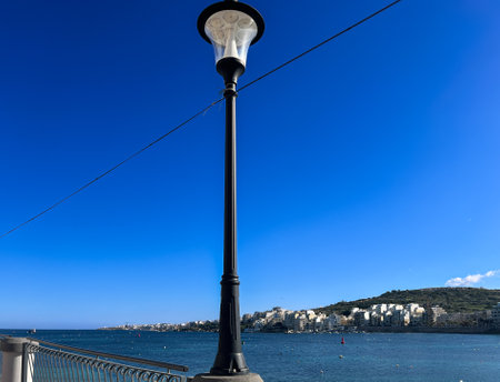 Lamppost and Coast and promenade of the town of Bugibba in Malta on a clear sunny dayの写真素材