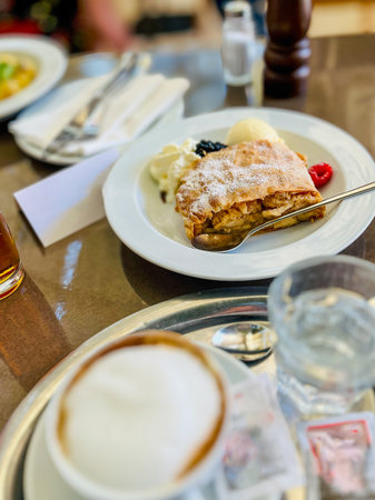 Delicious apple strudel with vanilla ice cream and fresh berries  with Wiener melange at Vienna restaurant.の写真素材